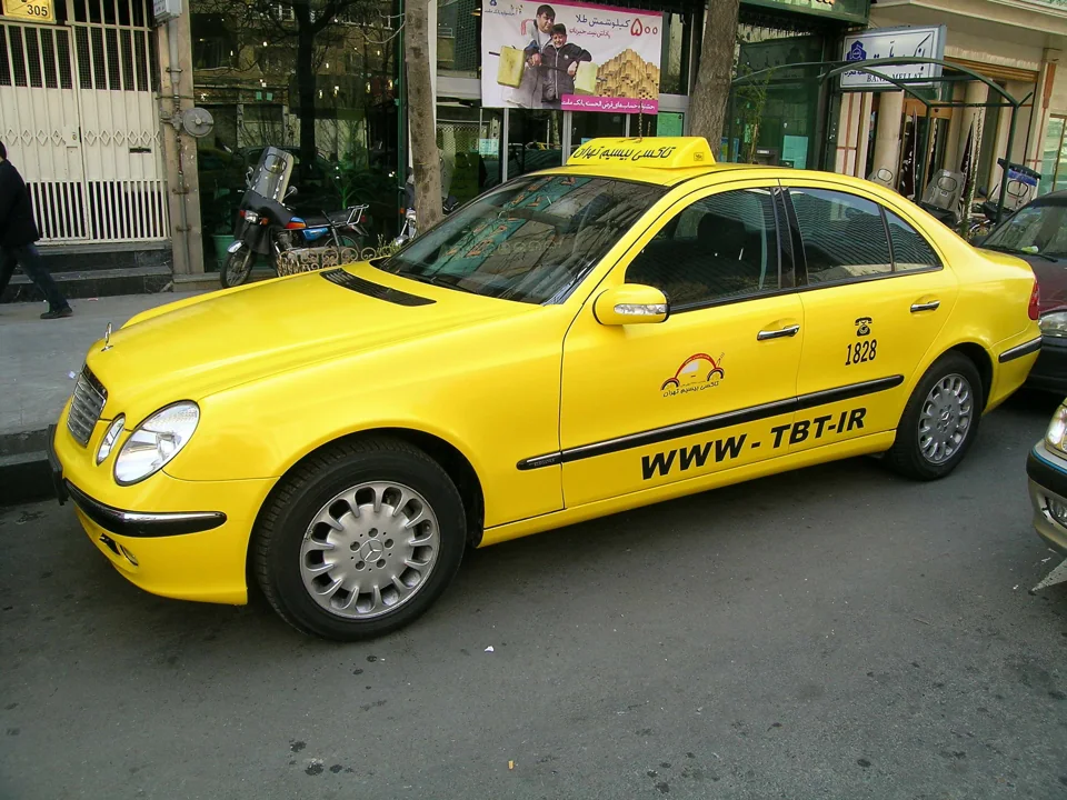 A yellow Mercedes-Benz with Taxi Bisim Tehran branding in the company archive